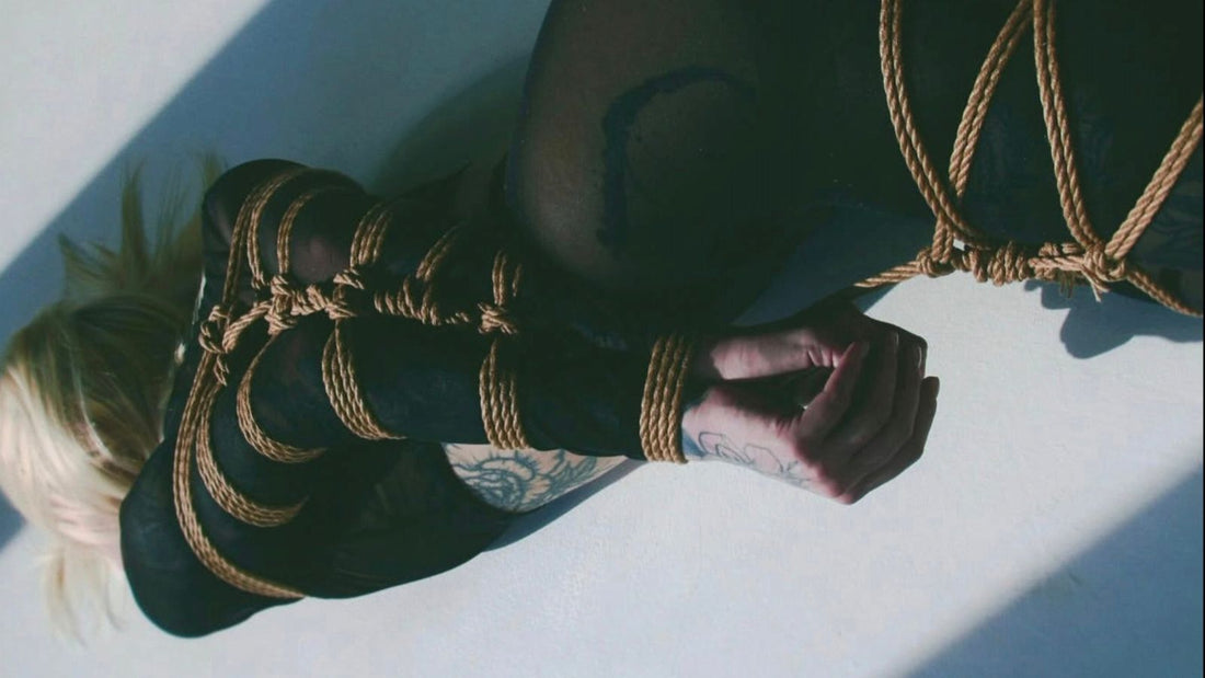 Natural jute shibari rope wrapped around the legs and arm of a reclining figure