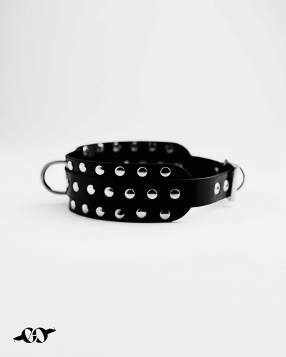 Close-up of studded black leather choker with silver studs and D-ring